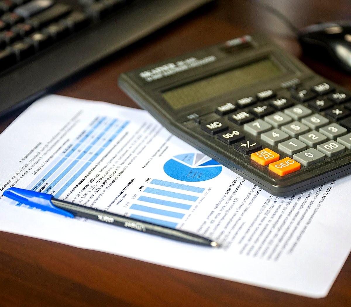serv-financeiro Relatório financeiro com gráficos ao lado de uma calculadora